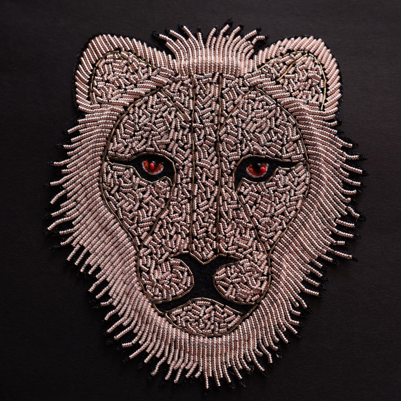 Embroidered patch of a lion's head on a black background