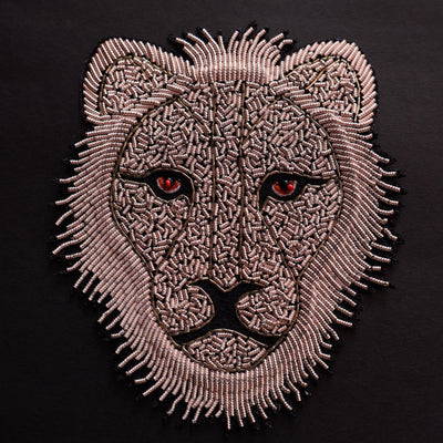 Embroidered patch of a lion's head on a black background